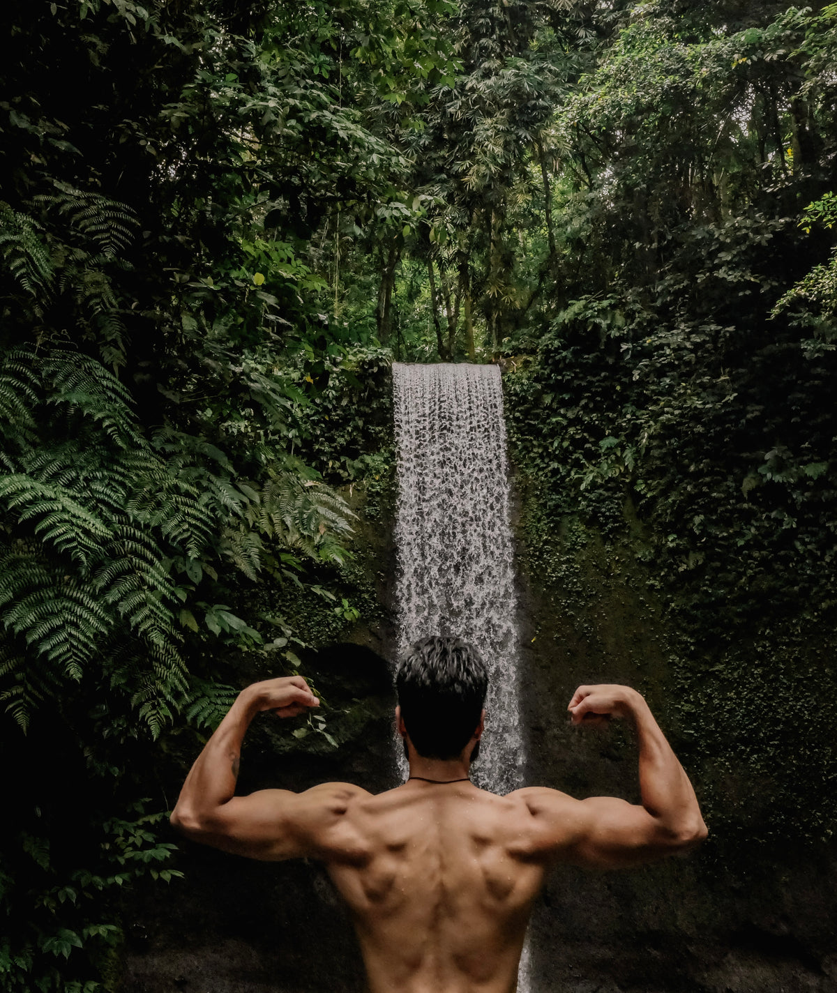 Taran facing a jungle waterfall